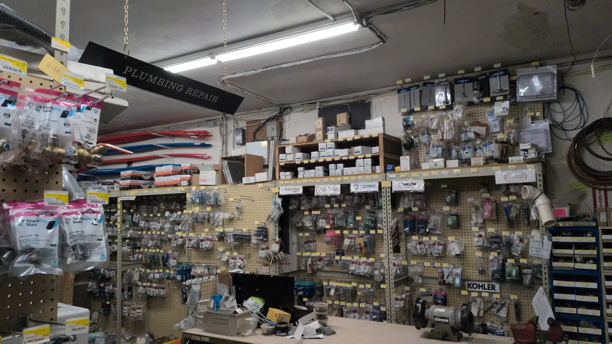 The plumbing repair counter with its hanging sign and walls of parts